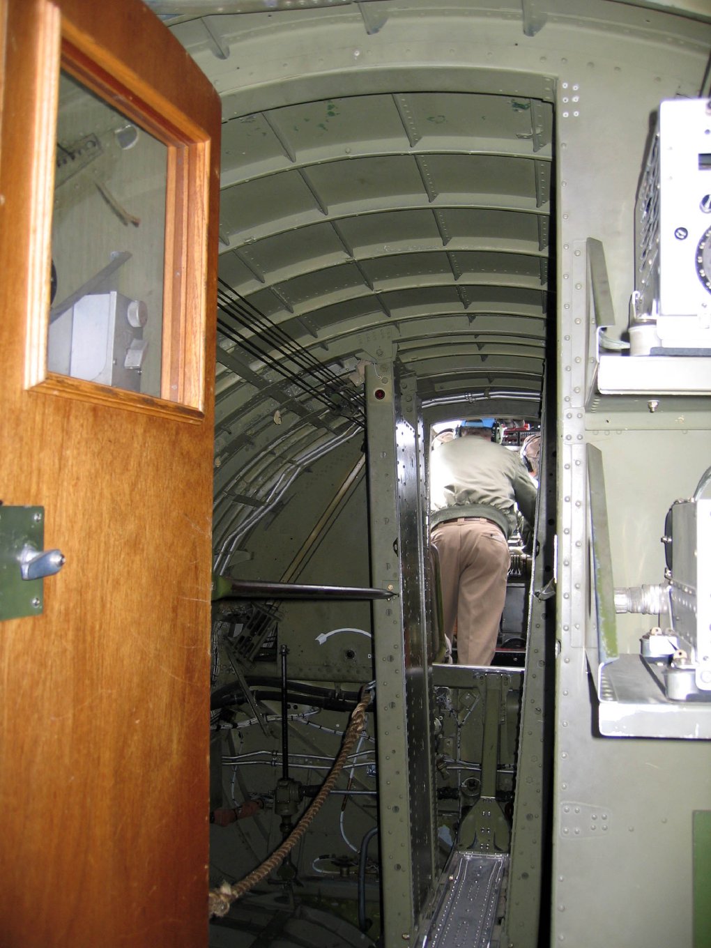 Looking forward from the radio room through an open door into the narrow bomb bay