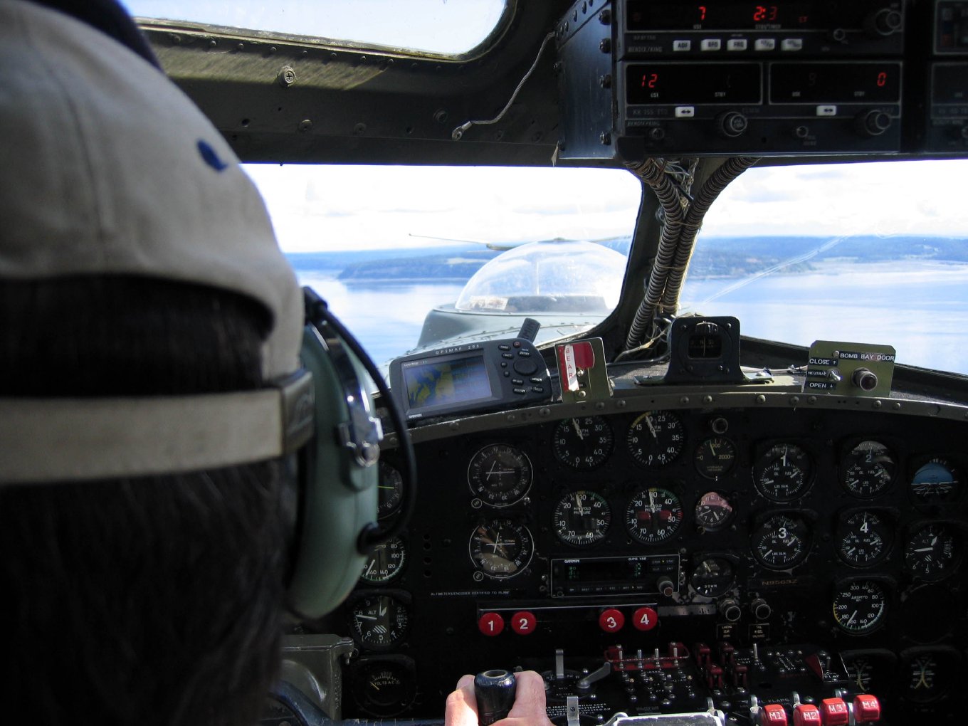 A pilot seen through the roof bubble of the nose compartment