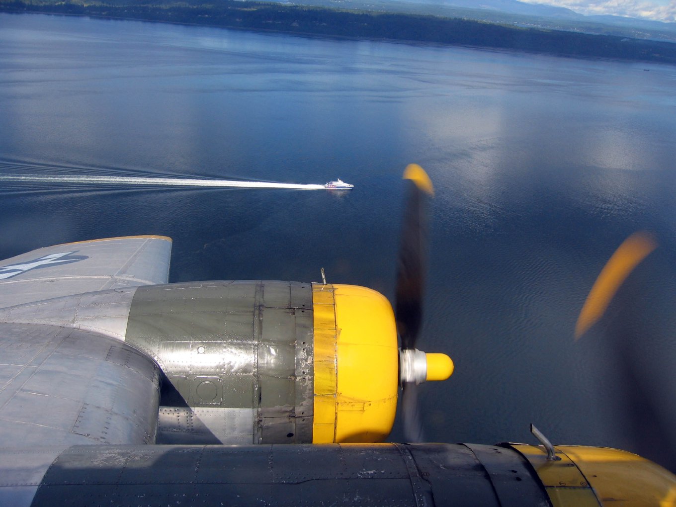 The Victoria Clipper's wake on the water below, past the B-17's engine