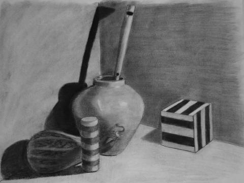 A charcoal still life of a vase with a paintbrush, a striped cylinder, a lemon and a striped box