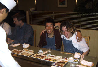 Daigo and Chris in aprons at a teppanyaki table, with the chef