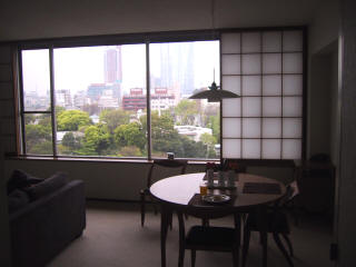 A dining table by a large window looking out on city towers