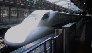 A white Shinkansen bullet train beside the station platform