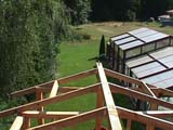 Looking down from the half-shingled roof toward the yard
