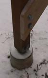 A post bolted to a metal post tie set in a concrete footing