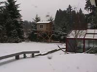 The platform house in a snowy yard, seen from our house