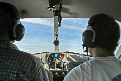 The view over the pilot's shoulders through the Beaver's windshield, on the water
